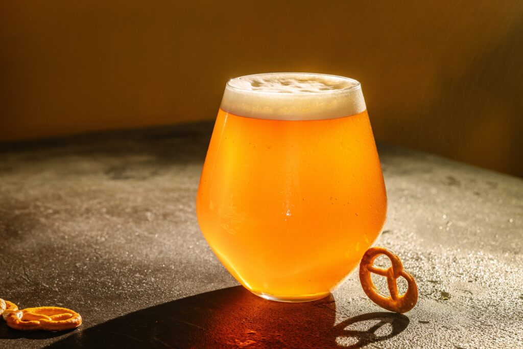close up of beer glass and a pretzel
