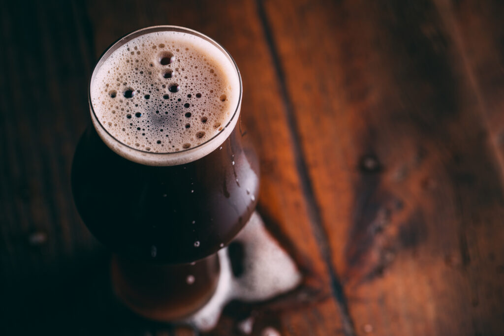 Stout beer in glass on dark background